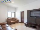 Modern living room with brown leather sofas and wall-mounted TV