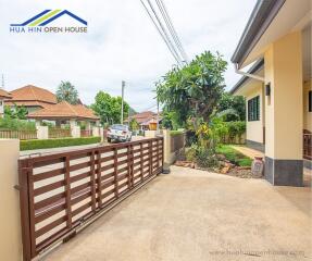 Gated driveway of a residential property with visible nearby houses