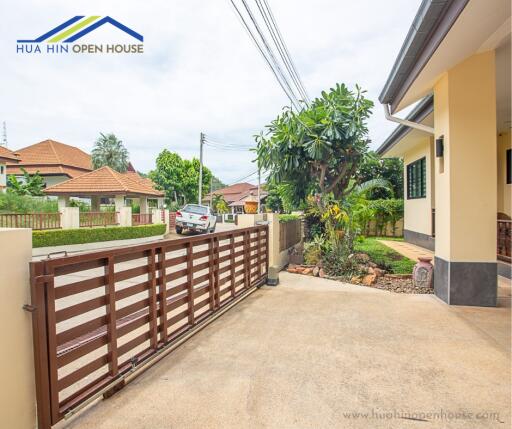 Gated driveway of a residential property with visible nearby houses