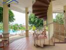 Outdoor lounge area with spiral staircase and pool view