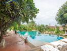 Outdoor pool with lounge chairs and surrounding greenery