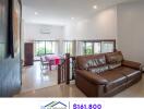 Spacious living room with brown leather sofa and adjoining dining area