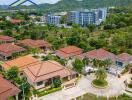 Aerial view of residential buildings with a lush green backdrop