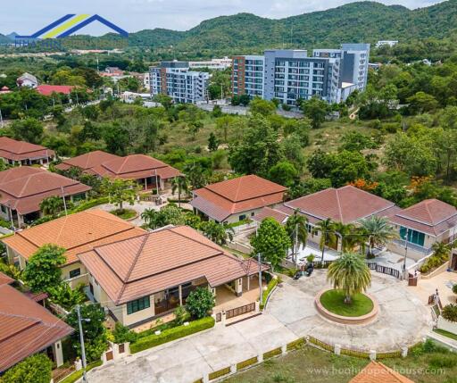 Aerial view of residential buildings with a lush green backdrop