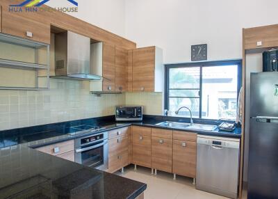 Modern kitchen with wooden cabinets and stainless steel appliances