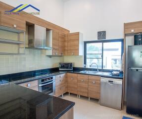 Modern kitchen with wooden cabinets and stainless steel appliances