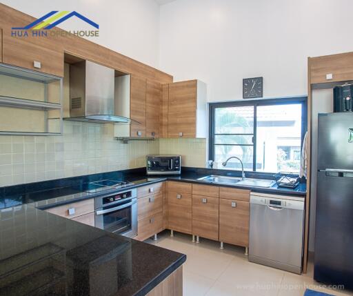 Modern kitchen with wooden cabinets and stainless steel appliances