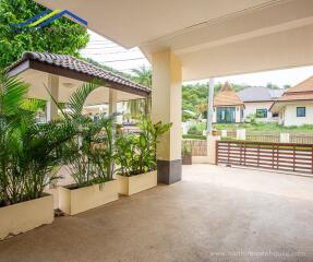 Outdoor view of the property with a covered area and surrounding greenery