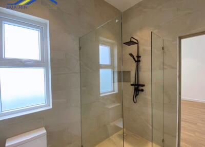 Modern bathroom with glass shower partition and wall-mounted showerhead