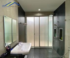 Modern bathroom with sink, mirror, and shower area