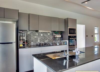 Modern kitchen with gray cabinets and black countertop