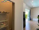 Hallway and partial view of living room with wooden flooring