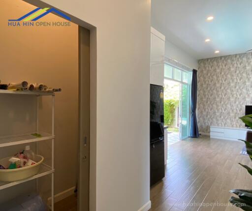 Hallway and partial view of living room with wooden flooring