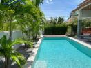 Outdoor pool area with lush greenery and seating