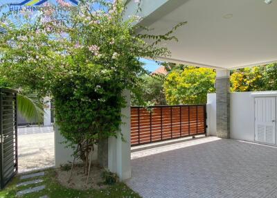 Covered driveway with gate and greenery