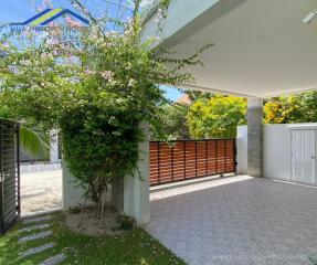 Covered driveway with gate and greenery