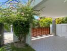 Covered driveway with gate and greenery