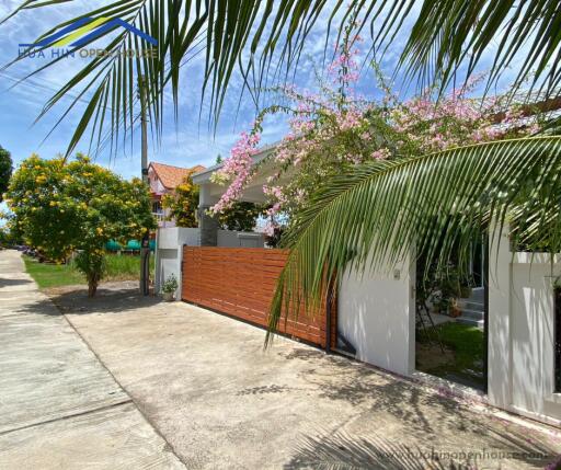 Beautiful exterior view of a house with a garden and wooden gate