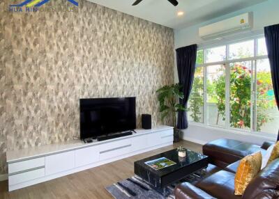 Modern living room with feature wall, large TV, and comfortable seating