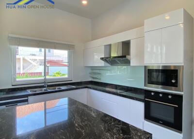 Modern kitchen with black marble countertops and white cabinets