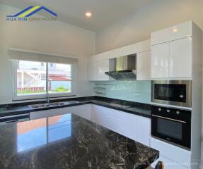 Modern kitchen with black marble countertops and white cabinets