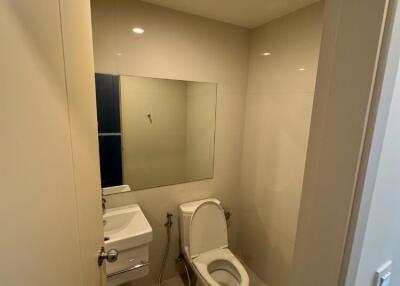 Modern bathroom with toilet, sink, and mirror