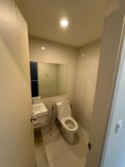 Modern bathroom with toilet, sink, and mirror