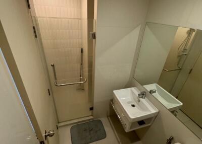 Modern bathroom with a glass shower door, wall-mounted sink, and a toilet