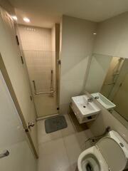 Modern bathroom with a glass shower door, wall-mounted sink, and a toilet