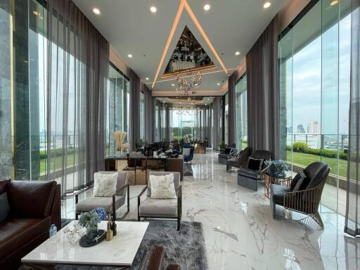 Spacious and luxurious living area with marble flooring, large windows, and modern furniture