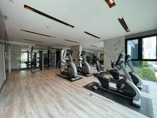 Modern gym with exercise equipment and large windows