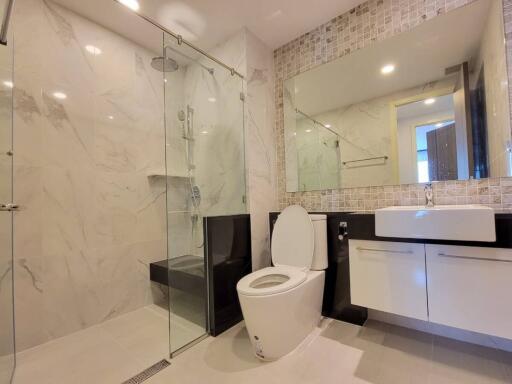 Modern bathroom with glass shower and large mirror