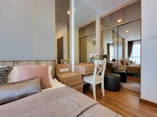 Modern bedroom with bed, vanity table, and seating area