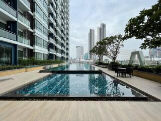 Outdoor swimming pool area with cityscape view