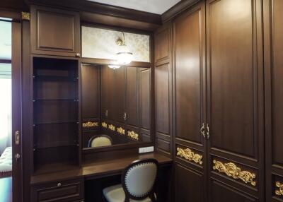 Elegant dressing room with wooden cabinetry and mirror