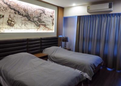 Modern bedroom with twin beds and wall-mounted air conditioner