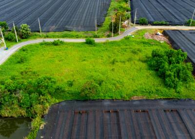 An aerial view of a plot of land surrounded by fields and a small building.