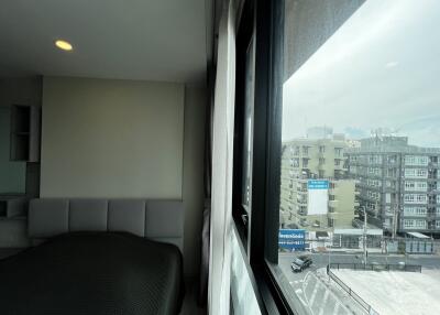 Modern bedroom with window view of urban buildings