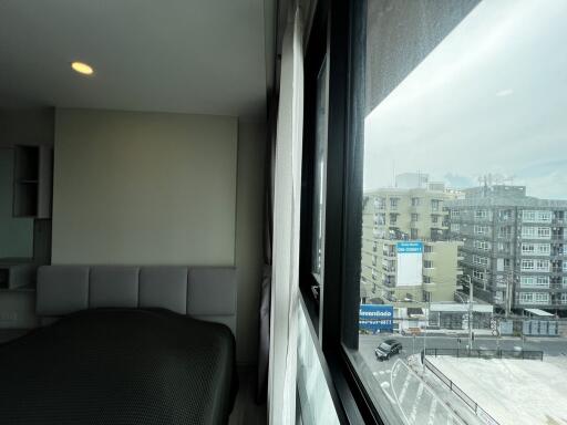 Modern bedroom with window view of urban buildings