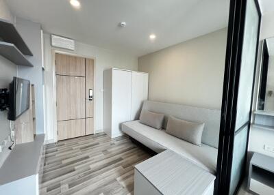 Modern living room with wooden flooring, couch, and storage