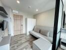 Modern living room with wooden flooring, couch, and storage