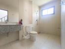 Modern bathroom with white tiles, a shower, toilet, and sink