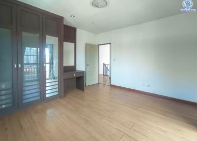 Spacious bedroom with wooden flooring and built-in wardrobe