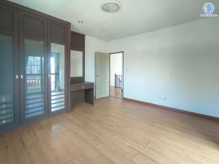 Spacious bedroom with wooden flooring and built-in wardrobe