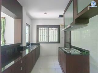 Modern kitchen with dark wooden cabinets and white countertops