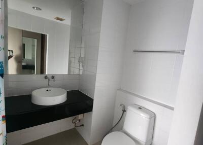 Bathroom with sink, toilet, and large mirror