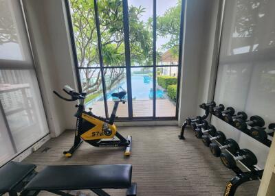 Home gym with exercise equipment and a view of the pool