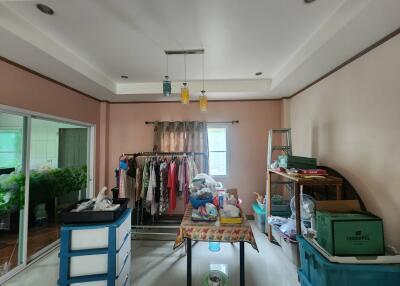 Room with hanging clothes, table, and miscellaneous items