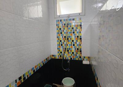 Bathroom with colorful tile accents and window