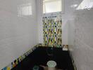 Bathroom with colorful tile accents and window